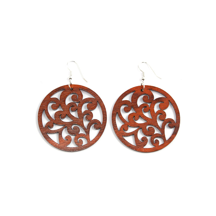 large wood earrings round with scrolling  design made from rosewood in costa rica