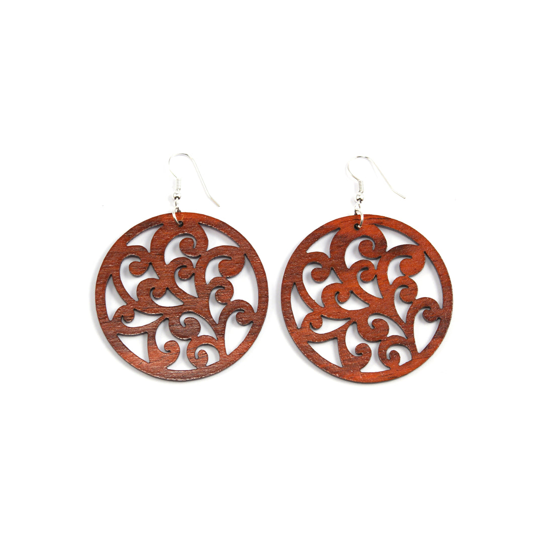 large wood earrings round with scrolling  design made from rosewood in costa rica