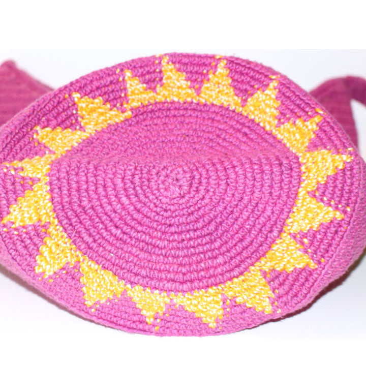 bottom view of large woven bag  pink bag with yellow sunburst pattern on round bottom
