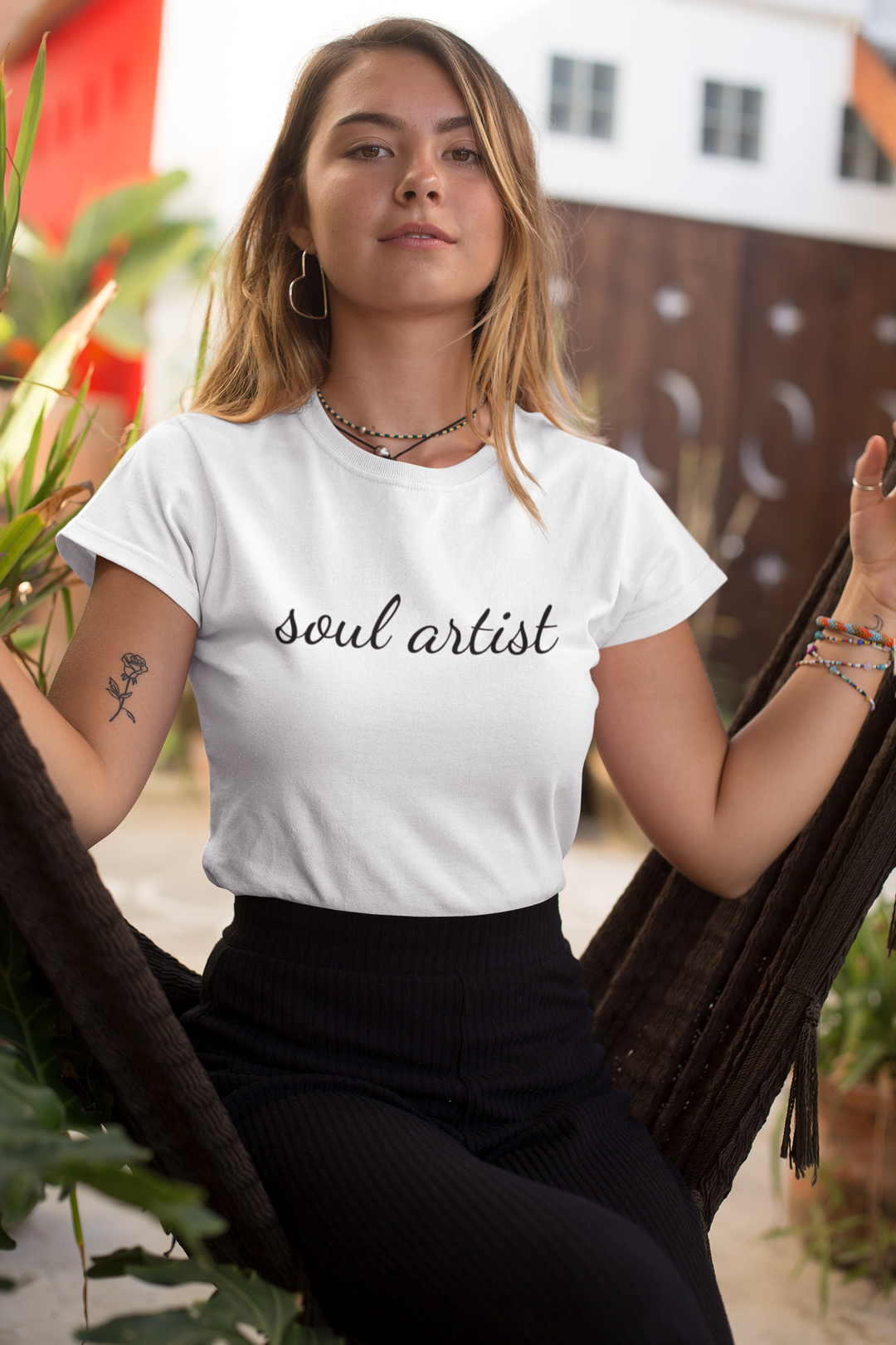 white t shirt with black writing that reads soul artist in  cursive writing being worn by model doing yoga